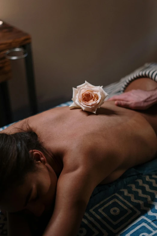 a man getting a back massage at a spa, by Jessie Algie, unsplash, laying on roses, petite girl, disrobed, moroccan