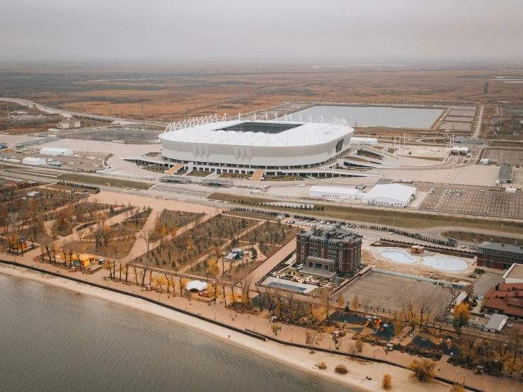 an aerial view of a stadium next to a body of water, by Alexander Fedosav, pexels contest winner, dieselpunk volgograd, white wall complex, thumbnail, high res 8k