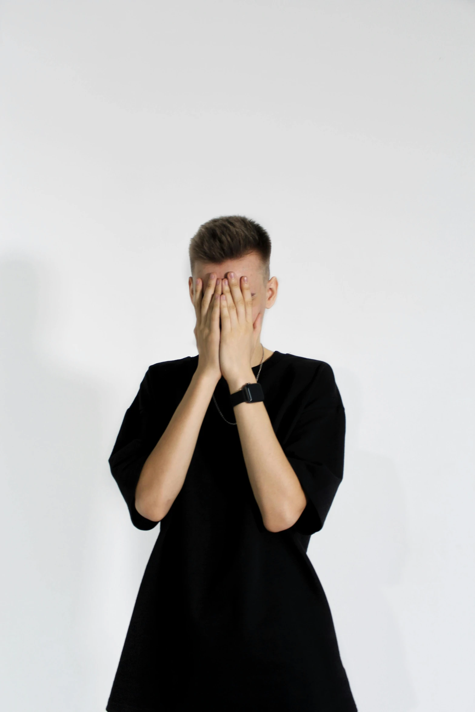 a man covers his face with his hands, pexels contest winner, antipodeans, non binary model, wearing a black shirt, giga chad crying, minimalistic