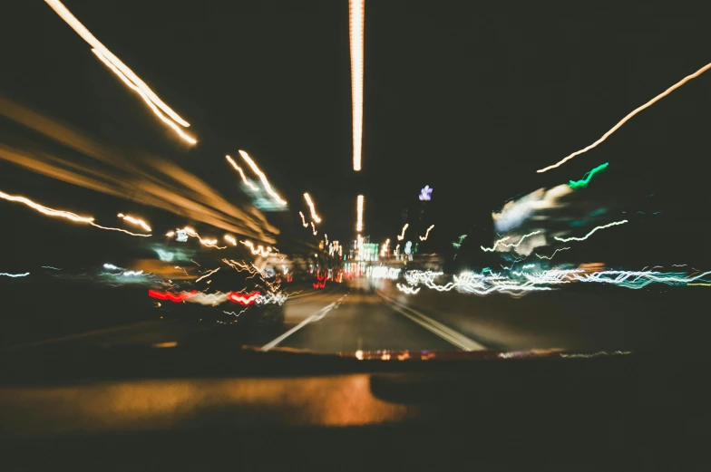 a blurry photo of a city street at night, unsplash, inside of a car, high speed, pov photo