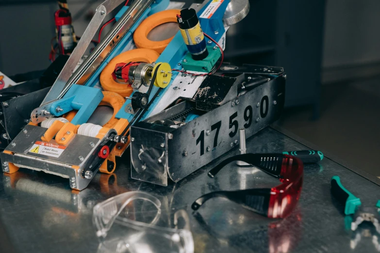 a bunch of tools sitting on top of a table, goggles, mechanical features and neon, profile image, f 1