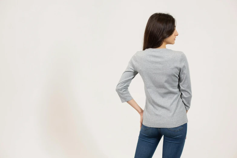 a woman standing with her back to the camera, grey sweater, full product shot, rectangle, high resolution image