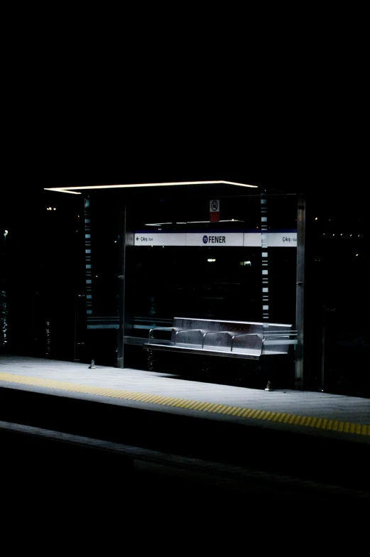 a train pulling into a train station at night, pexels, abandoned bus stop, square, minimalist photo, bench