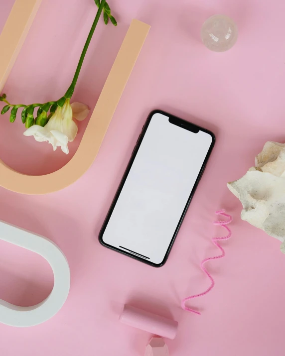 a cell phone sitting on top of a pink table, by Julia Pishtar, trending on pexels, lgbtq, skincare, white and black color palette, computer wallpaper