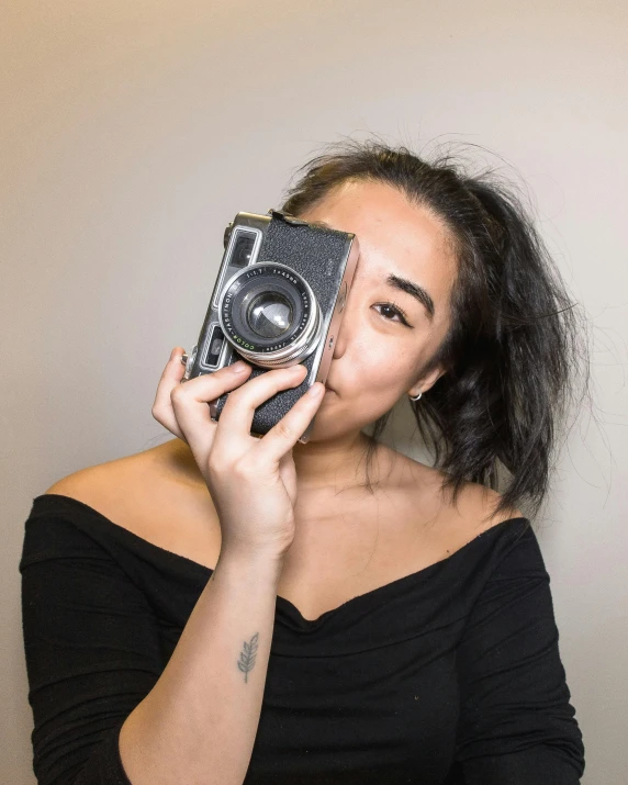 a woman taking a picture with a camera, inspired by Natasha Tan, queer woman, on a gray background, lovingly looking at camera, profile image