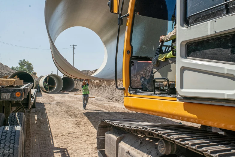 a large pipe laying on top of a dirt field, person in foreground, jcb, avatar image, 2 0 2 2 photo