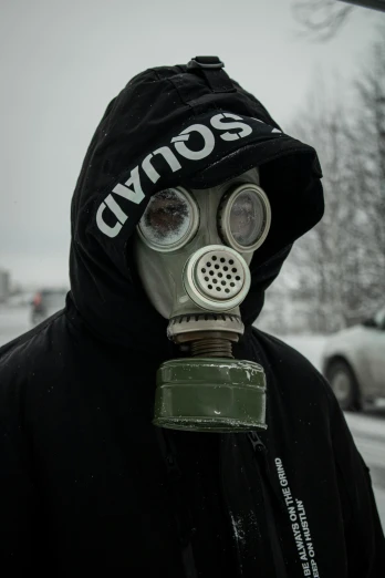a man wearing a gas mask in a parking lot, an album cover, reddit, nuclear art, cold winter, headshot profile picture, scp 3008, streetwear