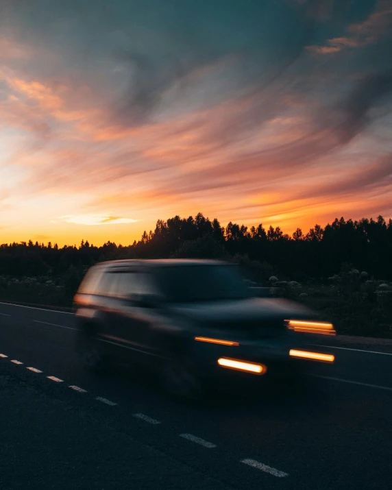 a car driving down a highway at sunset, by Jesper Knudsen, sunset lighting ominous shadows, profile picture, low quality photo, off-roading