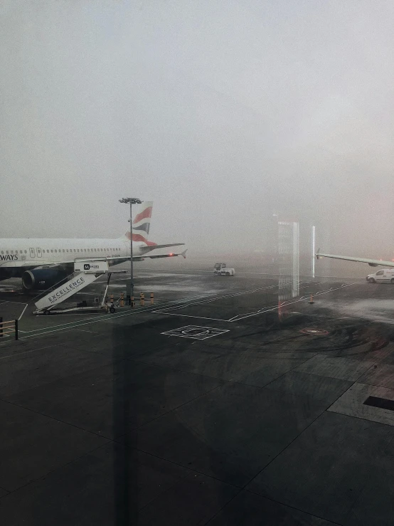 a large jetliner sitting on top of an airport tarmac, a picture, by Romain brook, happening, foggy heavy rain, in london, phone photo, looking out of the window