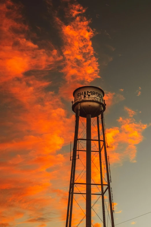 a water tower with a red sky in the background, a portrait, by Greg Staples, art photography, square, panoramic, alabama, today\'s featured photograph 4k