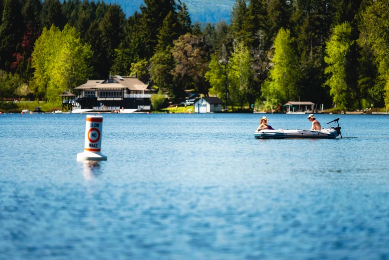 a couple of people in a boat on a lake, a tilt shift photo, by Tom Bonson, pexels contest winner, tubing, some floating billboards, british columbia, thumbnail