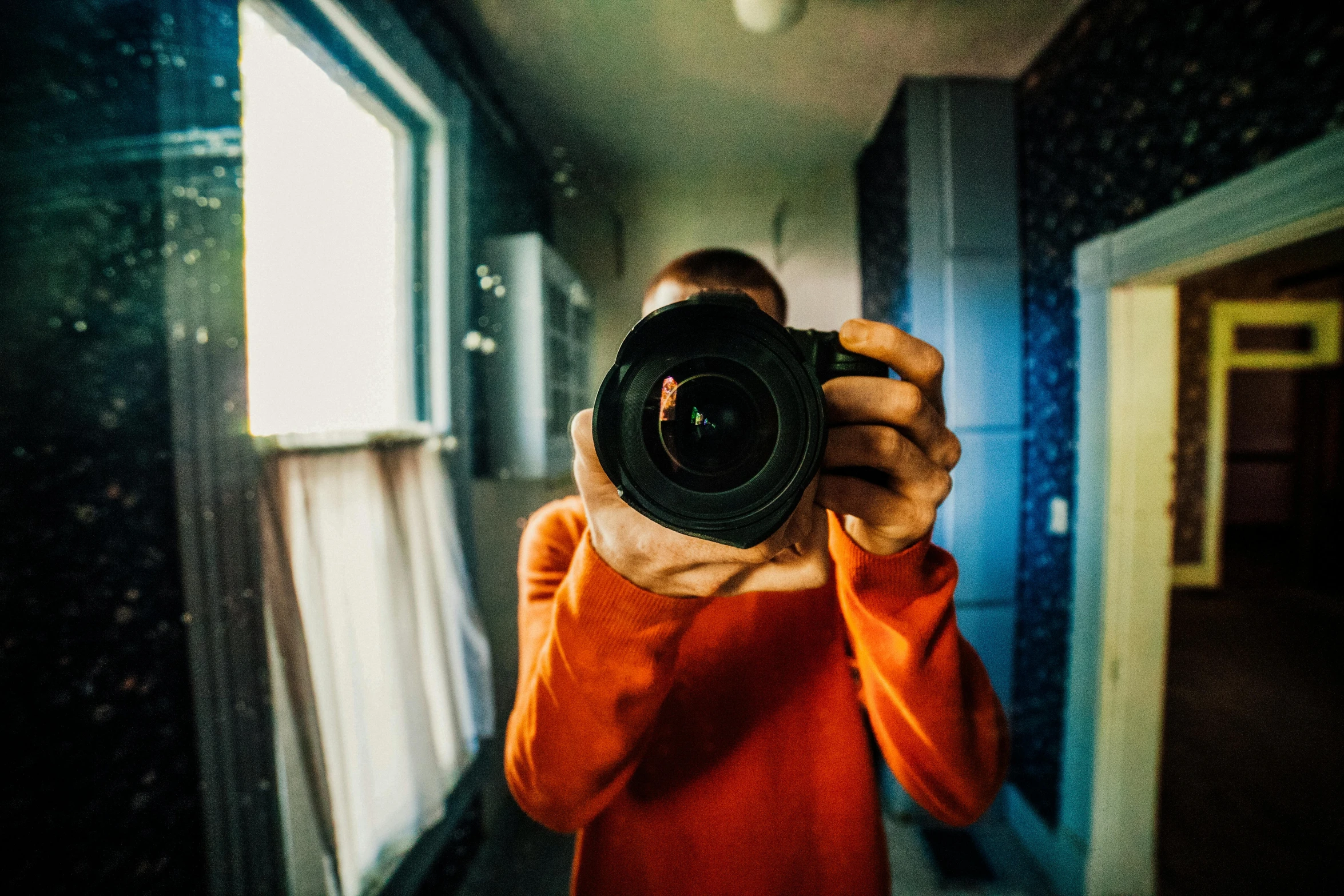 a person taking a picture with a camera, by Julia Pishtar, view from behind mirror, bright colors ultrawide lens, professional photography canon, looks directly at camera