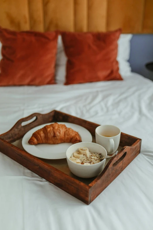 a tray of food sitting on top of a bed, morning coffee, orange and white color scheme, wooden bowl, set photograph