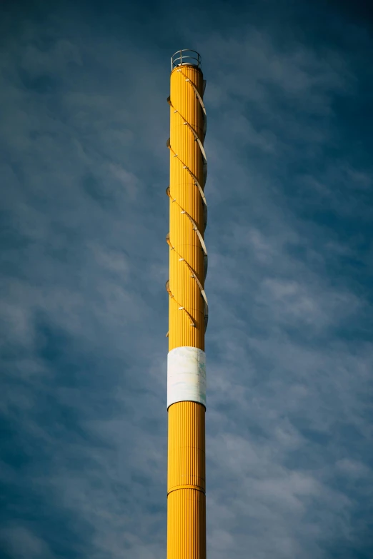 a tall yellow pole with a blue sky in the background, by Sven Erixson, spiral smoke, detailed product image, overcast, telephoto