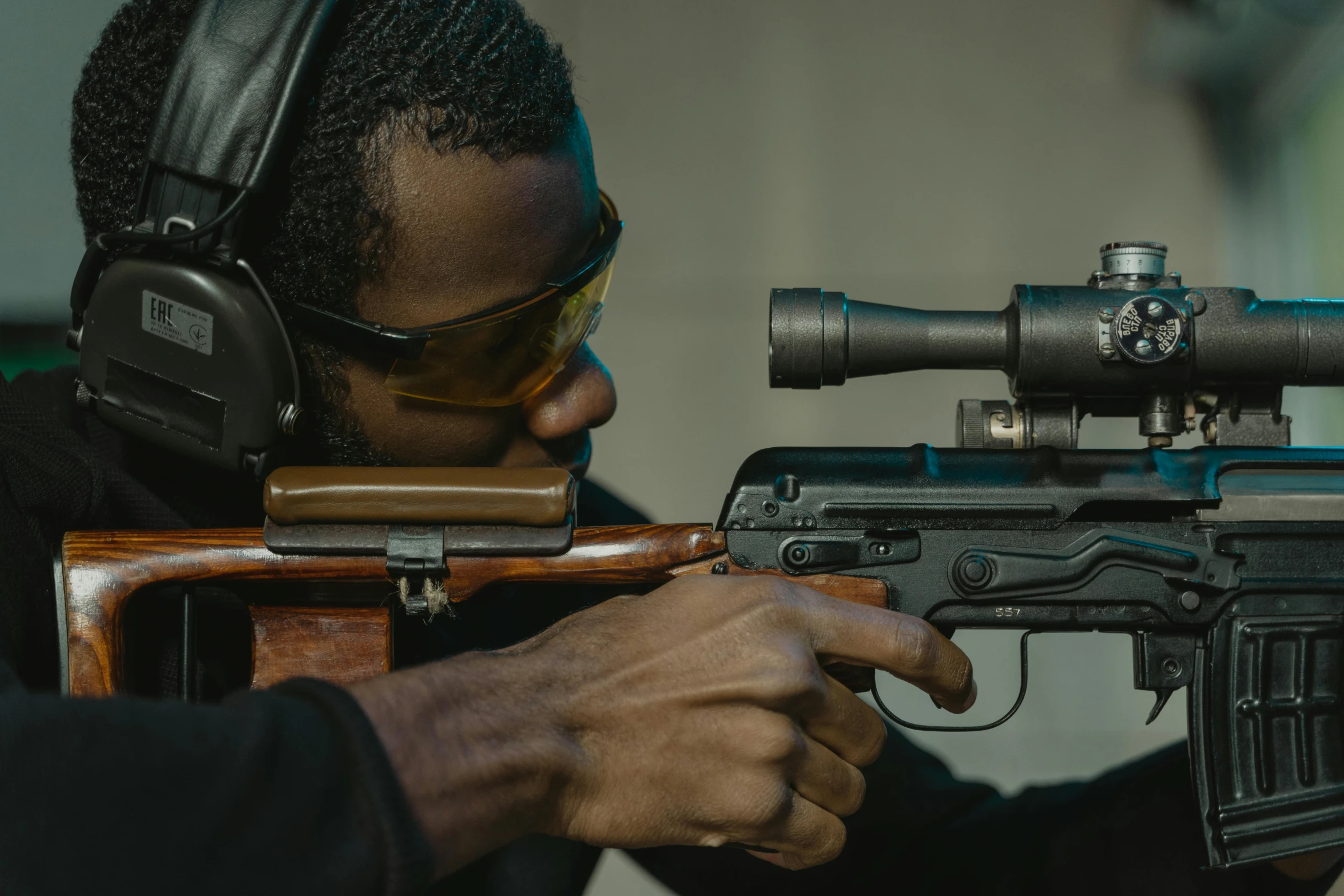 a man holding a rifle while wearing headphones, pexels contest winner, jemal shabazz, target reticles, spying discretly, ar glasses