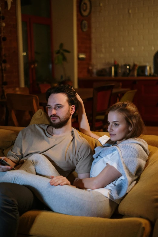 a man and a woman sitting on a couch, watching tv, comfy lighting, connectivity, square