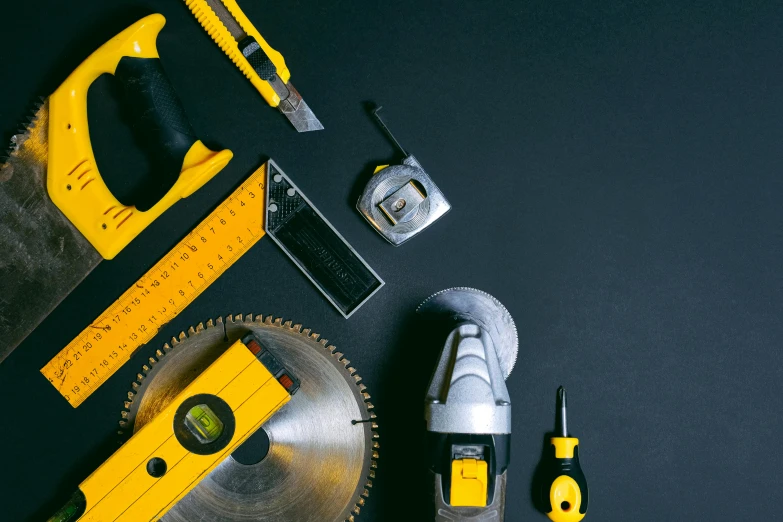 a group of tools sitting on top of a table, black and yellow, profile image, saw, circular