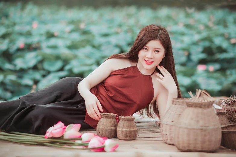 a woman laying on the ground next to a basket of flowers, pexels contest winner, beautiful asian girl, standing gracefully upon a lotus, avatar image, maroon