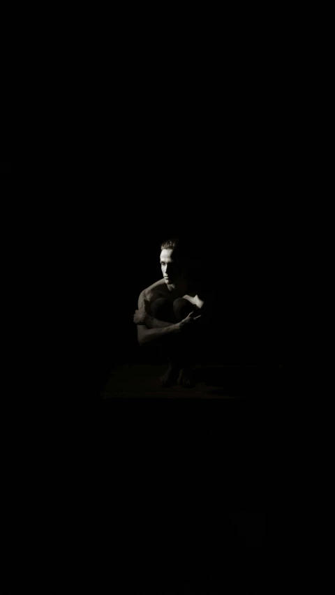 a black and white photo of a man kneeling in the dark, minimalism, high quality photo, abstract claymation, studio medium format photograph, full body image
