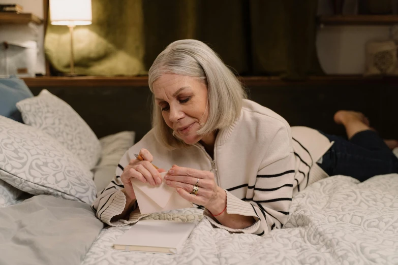 a woman laying on a bed reading a book, pexels contest winner, hyperrealism, smoking a joint, dementia, silver，ivory, embroidered velvet