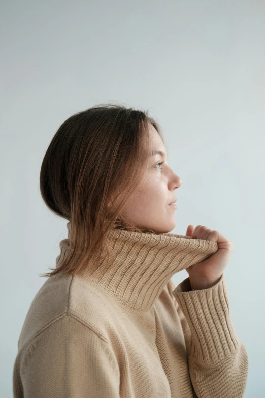 a woman wearing a turtle neck sweater, trending on pexels, visual art, light borwn hair, big collar, view from the side, tan