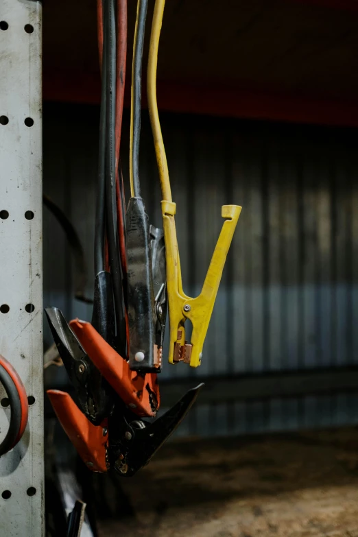 a bunch of tools sitting on top of a metal shelf, by David Simpson, pexels contest winner, figuration libre, rubber hose style, black and yellow and red scheme, large chain, hay