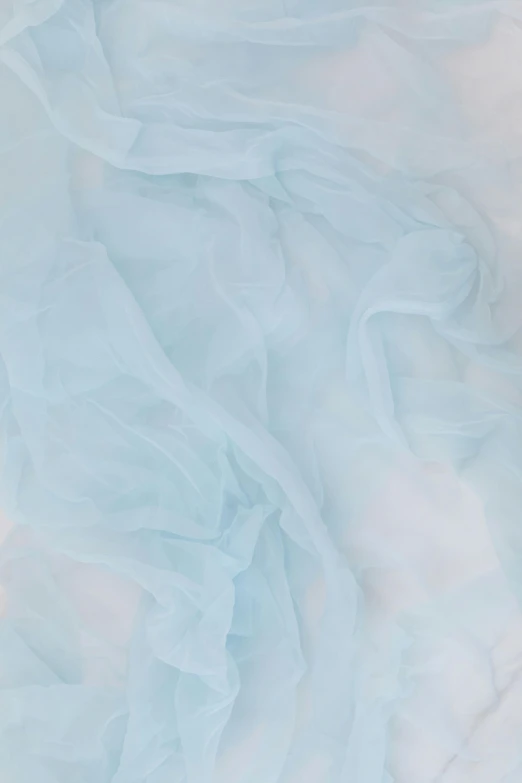 a cat laying on top of a bed covered in a blue sheet, cotton candy, detailed product image, sheer fabrics, detail shot