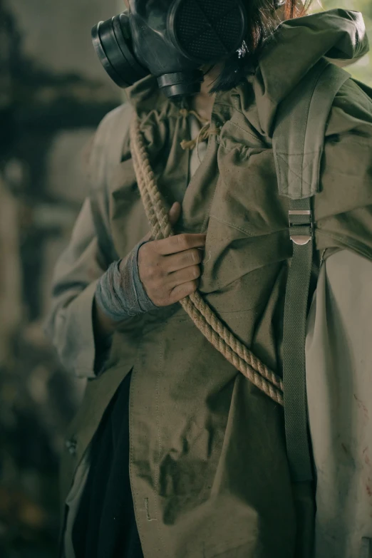 a man wearing a gas mask and a backpack, trending on unsplash, renaissance, rope bondage, film still from the movie, ww1 trench, cloak. extremely high details