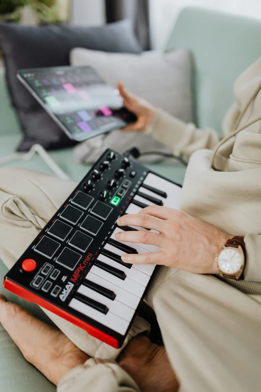 a man that is sitting on a couch with a keyboard, mpc, instagram picture, handheld, ap