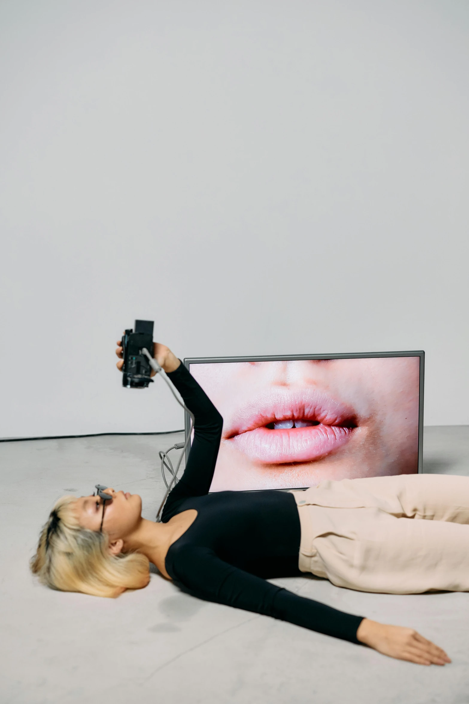 a woman laying on the ground in front of a television, inspired by Sarah Lucas, reddit, video art, pursed lips, two models in the frame, ultra accurate, with mouth open