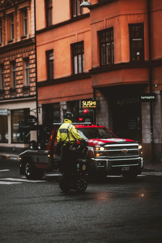 a man riding a motorcycle down a street next to tall buildings, by Adam Marczyński, pexels contest winner, happening, ambulance, sweden, full view of a car, 🚿🗝📝