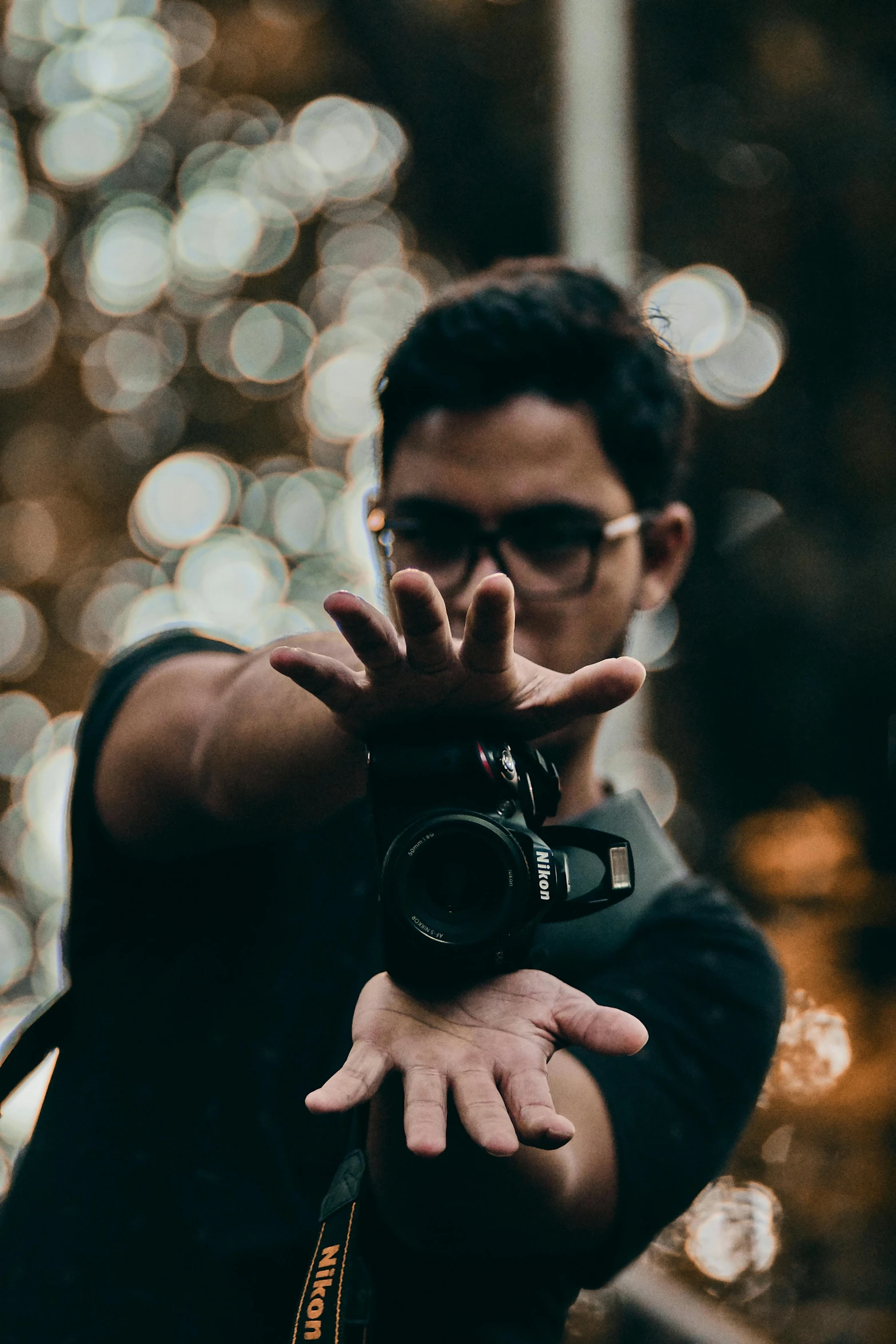 a man taking a picture with his camera, by Robbie Trevino, bokeh top cinematic lighting, fight pose, hand gesture, man with glasses