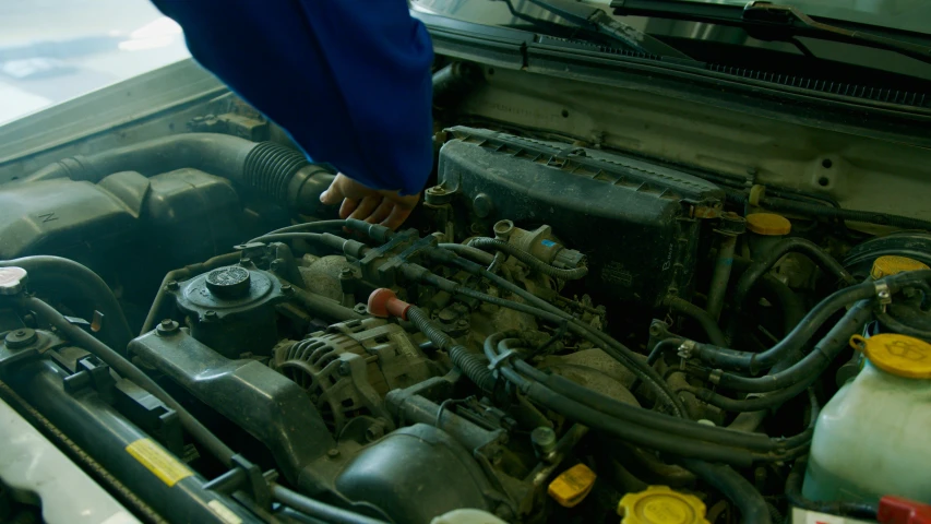 a man is working on a car engine, by David Simpson, pexels contest winner, cinematic still frame, blue, brown, worksafe. cinematic