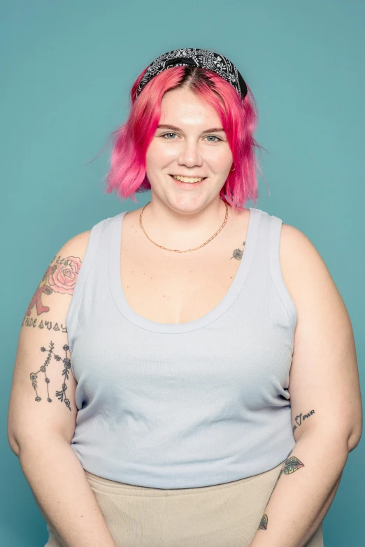 a woman with pink hair posing for a picture, slightly overweight, ethan klein, high res photograph, with tattoos