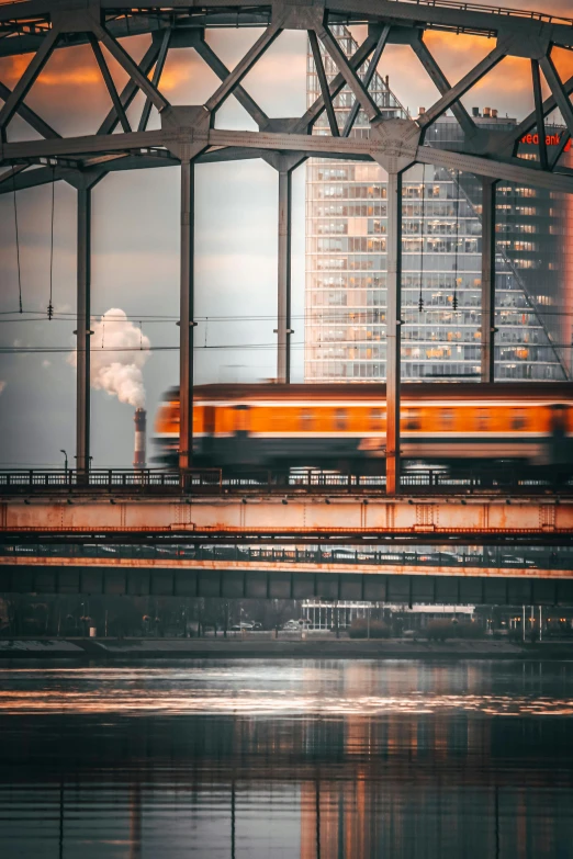 a train traveling across a bridge over a river, by Daniel Seghers, pexels contest winner, modernism, industrial colours, 🚿🗝📝