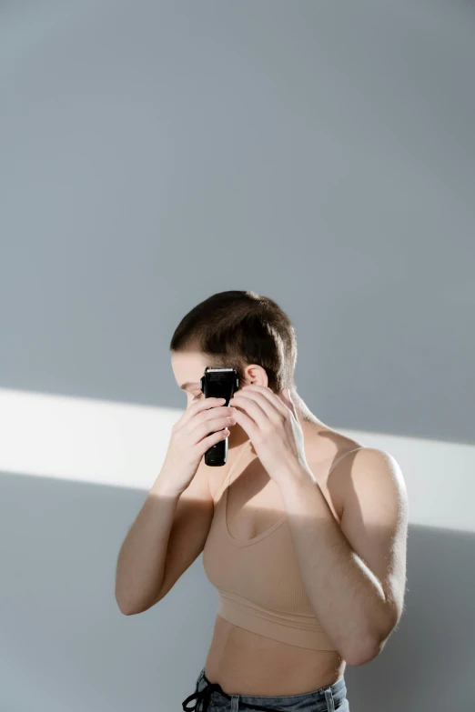 a man taking a picture of himself in a mirror, trending on pexels, minimalism, disrobed, buzz cut hair, cell phones, julian ope