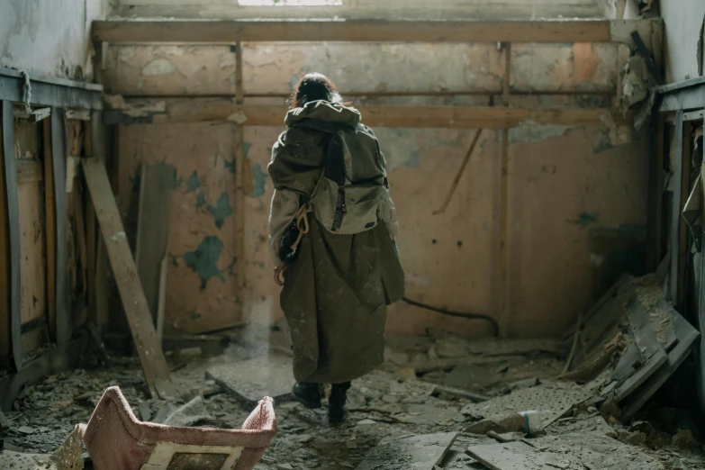 a woman in a trench coat walking through an abandoned building, by maxim verehin, pexels contest winner, carrying survival gear, [ theatrical ], a man wearing a backpack, still from movie