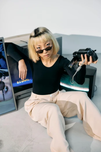 a woman sitting on a bed holding a camera, an album cover, inspired by Zhu Da, trending on pexels, realism, futuristic ar glasses, video game character, in an action pose, portrait a woman like reol