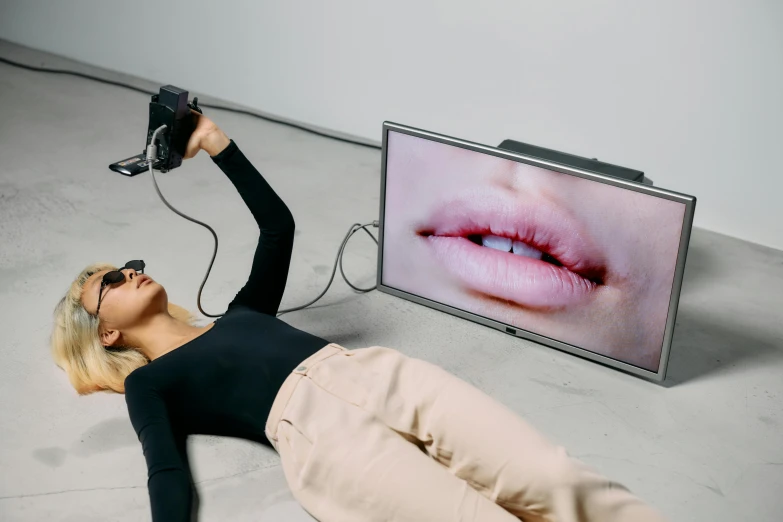 a woman laying on the ground in front of a television, inspired by Marina Abramović, trending on pexels, video art, kiss mouth to mouth, digital glasses, hypperrealistic 3 d sculpture, trending on dezeen