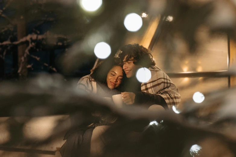 a couple sitting next to each other on a bench, by Adam Marczyński, pexels contest winner, happening, christmas, soft lights, avatar image, hug