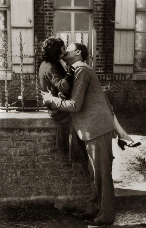 a black and white photo of a man kissing a woman, by Kees Scherer, bauhaus, early 2 0 th century, in front of the house, promo image, b - roll