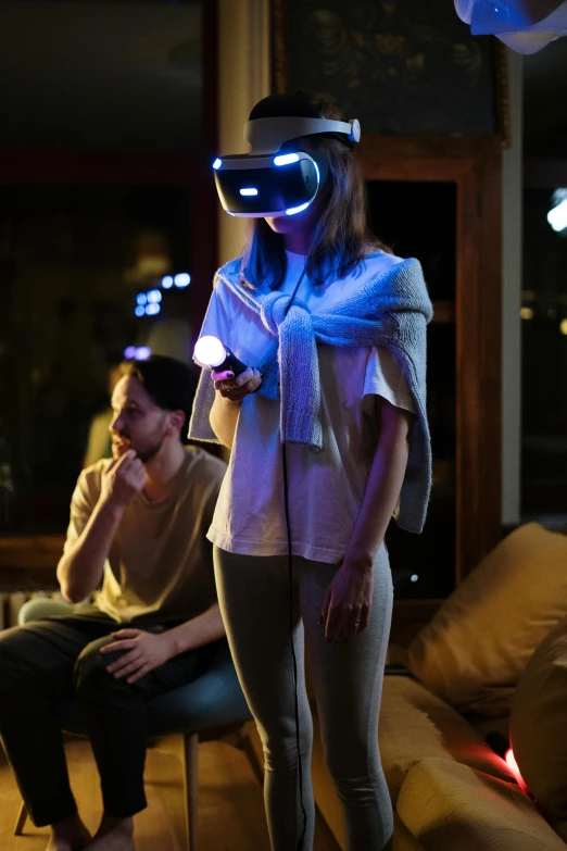 a woman standing next to a man in a living room, a hologram, interactive art, gaming headset, taken with sony alpha 9, mid night, holding controller