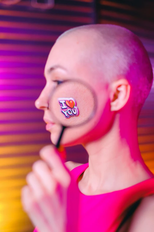 a woman holding a magnifying glass in front of her face, an album cover, inspired by INO, antipodeans, buzz cut, fluorescent pink face paint, i love you, silicone patch design