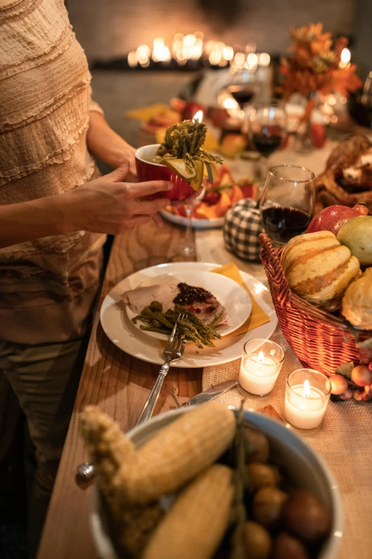 a woman standing in front of a table filled with food, pexels, renaissance, harvest fall vibrance, candlelit, wisconsin, square