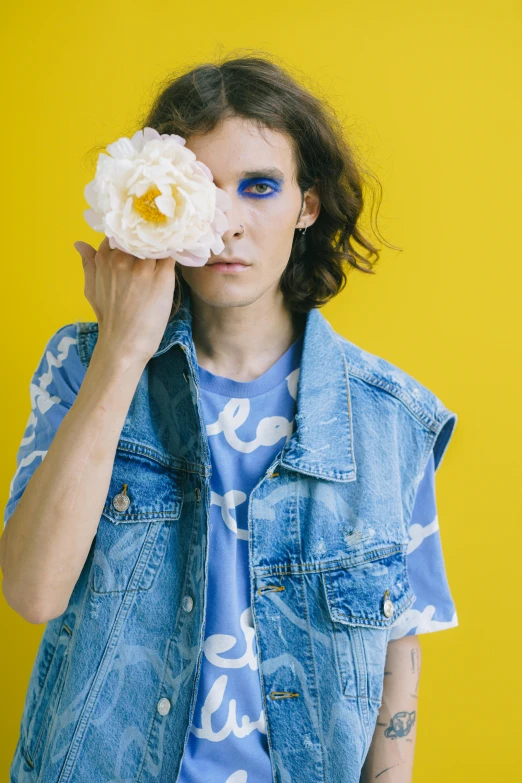 a woman holding a flower in front of her face, an album cover, trending on pexels, aestheticism, a photo of a disheveled man, nonbinary model, wearing a blue jacket, toiletpaper magazine