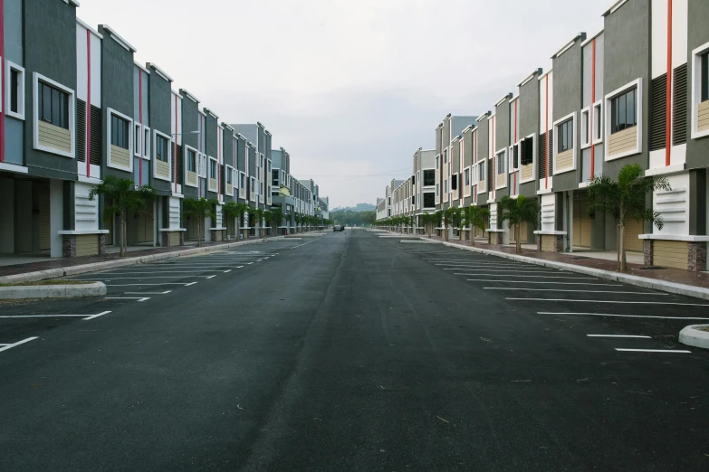 a street lined with lots of buildings next to each other, inspired by Thomas Struth, unsplash, concrete housing, deserted, chengwei pan, suburbs