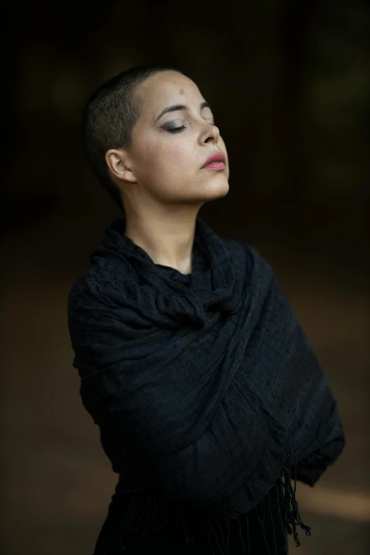 a woman wearing a black shawl in a dark room, an album cover, by Winona Nelson, unsplash, mixed race woman, shaven, woods, 15081959 21121991 01012000 4k