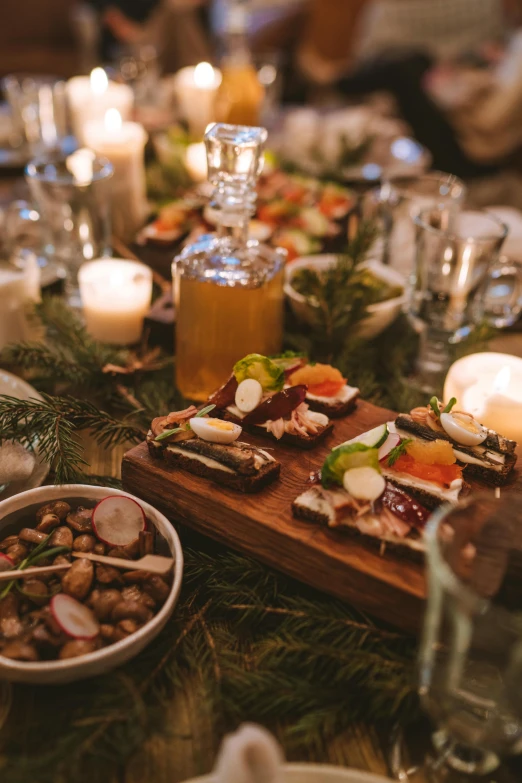 a table topped with plates of food and candles, square, close medium shot, food, lights