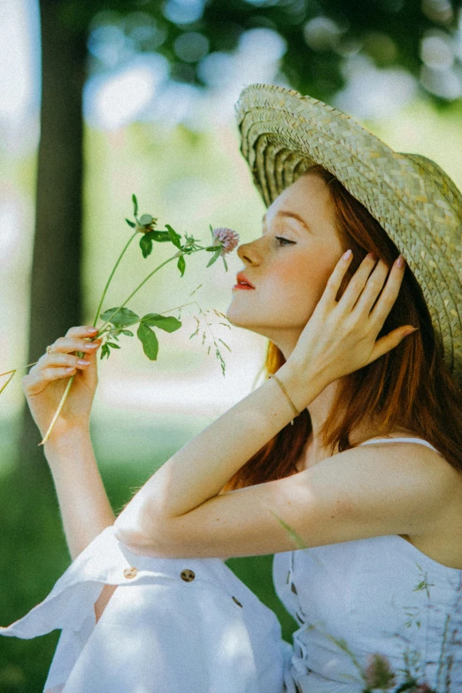 a woman in a straw hat holding a flower, pexels contest winner, romantic greenery, profile image, branches sprouting from her head, smelling good