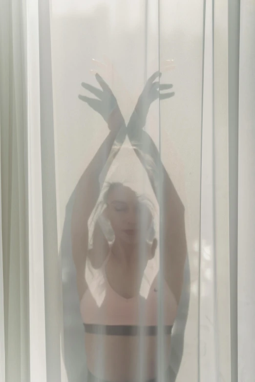 a woman that is standing in front of a window, an album cover, inspired by Elsa Bleda, unsplash, conceptual art, shower cap, hands up, nick knight, soft aesthetic